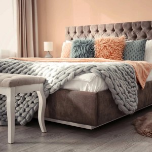 Schlafzimmer mit Wand in warmem Pfirsichton, gestrichen mit matter Wandfarbe. Zeigt gemütliche Raumgestaltung.