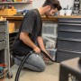 Mann nutzt Kärcher Fugendüse für Nass-/Trockensauger zur Reinigung einer Ecke.