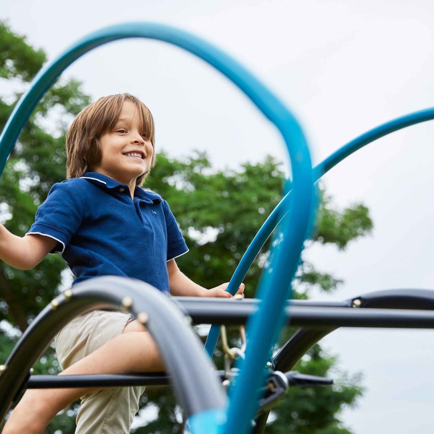 Kind klettert auf TP Toys Sitzschaukel/Hängesessel UFO in Schwarz-Blau. Spiel & Spaß im Garten.