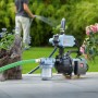 Hauswasserautomat 800 W im Einsatz zur Gartenbewässerung. Pumpe mit Schlauch und Blumen im Hintergrund.