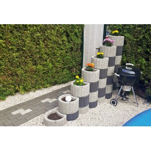 Gestapelte anthrazitfarbene Pflanzringe Klein 35x20 cm mit Blumen und Grill im Garten.