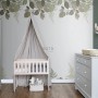 Kinderzimmer mit Fototapete Waldtiere in Grün/Braun, eingerichtet mit Babybett, Kommode und Schrank.