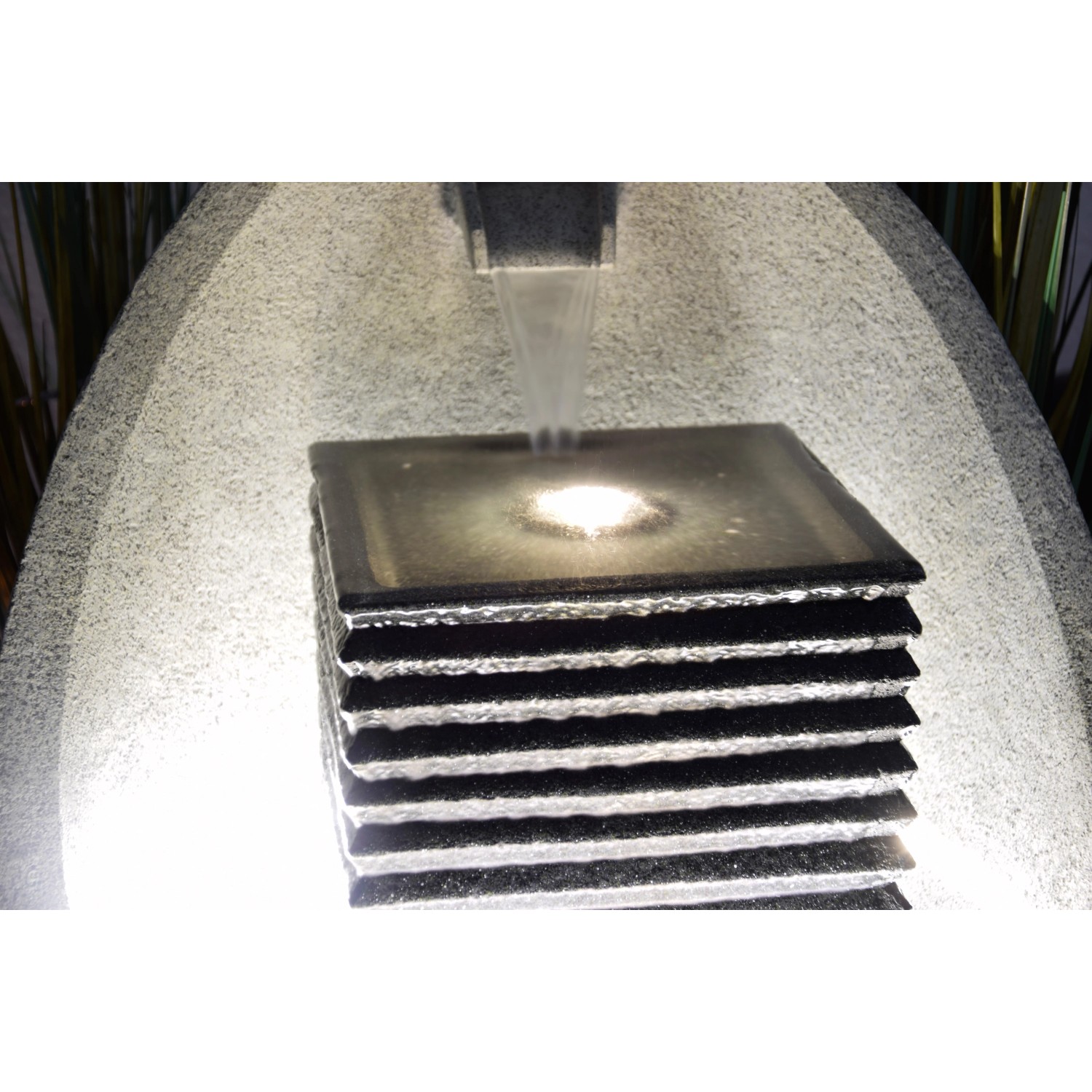 Großer, ei-förmiger Design-Gartenbrunnen mit LED-Beleuchtung und Wasserspiel.