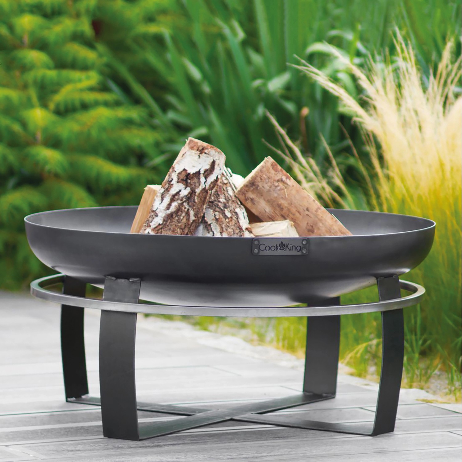 Wilk Feuerschale Viking, Ø 60 cm, aus Stahl mit Holzscheiten im Garten.