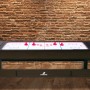 Reverso Spieltisch als Airhockey-Tisch mit roten Pucks vor Backsteinwand.