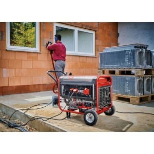 Roter, robuster Einhell Benzin-Stromerzeuger TC-PG 65/E5 auf Rädern versorgt Werkzeug auf Baustelle.