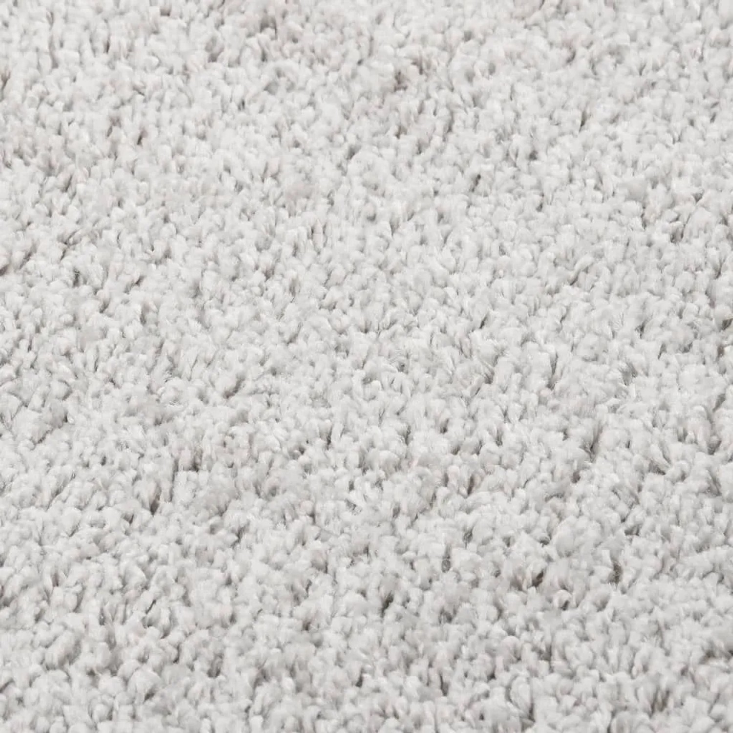Nahaufnahme eines hellgrauen Shaggy-Teppichs mit weicher, dichter Hochflor-Textur. Ideal für Komfort und Wärme.