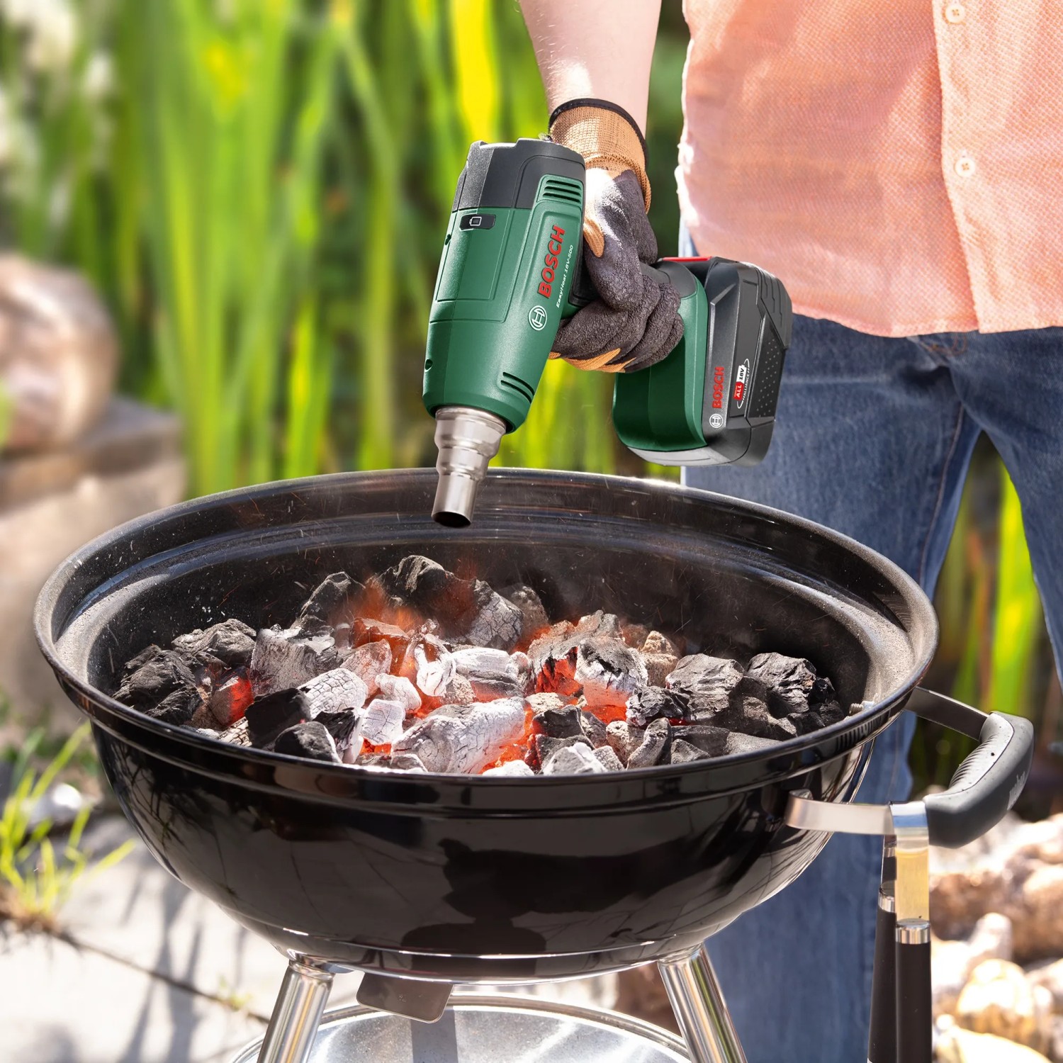 Bosch Akku-Heißluftgebläse EasyHeat 18V-500 beim Anzünden von Grillkohle.