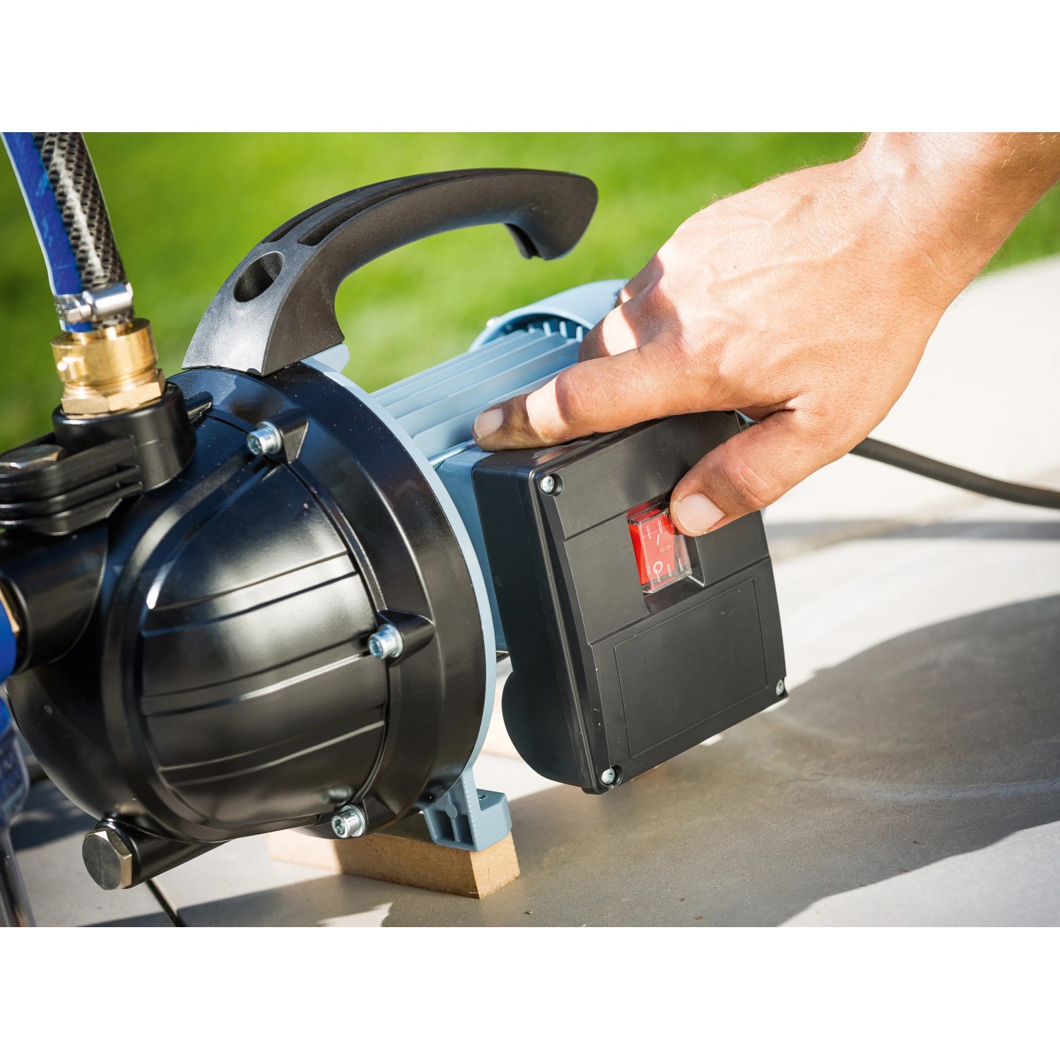 Gartenpumpe GP 3200 (800 W) im Betrieb: Hand betätigt Schalter. Ideal zur Gartenbewässerung.