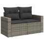 Graue 2-Sitzer Garten-Sofagarnitur aus Polyrattan mit dunklen Kissen.