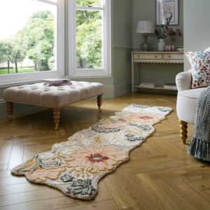 Flair Rugs Wollteppich Daphne Floral, mehrfarbig, mit geformten Kanten und Blumenmuster auf Holzfußboden.