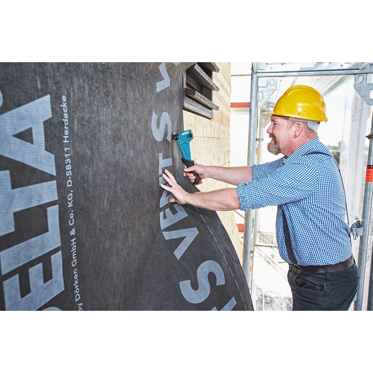 Handwerker befestigt Folie mit Novus Hammertacker. Der Tacker ist blau und schwarz.
