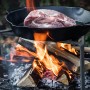 Petromax Feuerpfanne FP30-T: Gusseisenpfanne mit Stiel über offenem Feuer mit Fleisch.