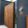 Moderne Lutec LED-Außenwandleuchte Maya in Edelstahloptik mit Up & Down Lichteffekt an dunkler Hauswand.