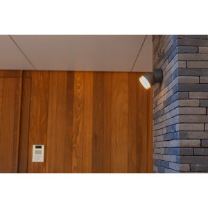 Anthrazitfarbene Lutec LED-Außenwandleuchte Dropsi an einer Backsteinwand.