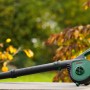 Bosch Akku-Laubbläser UniversalLeafBlower 18V-130 mit Akku und Ladegerät im Garten.