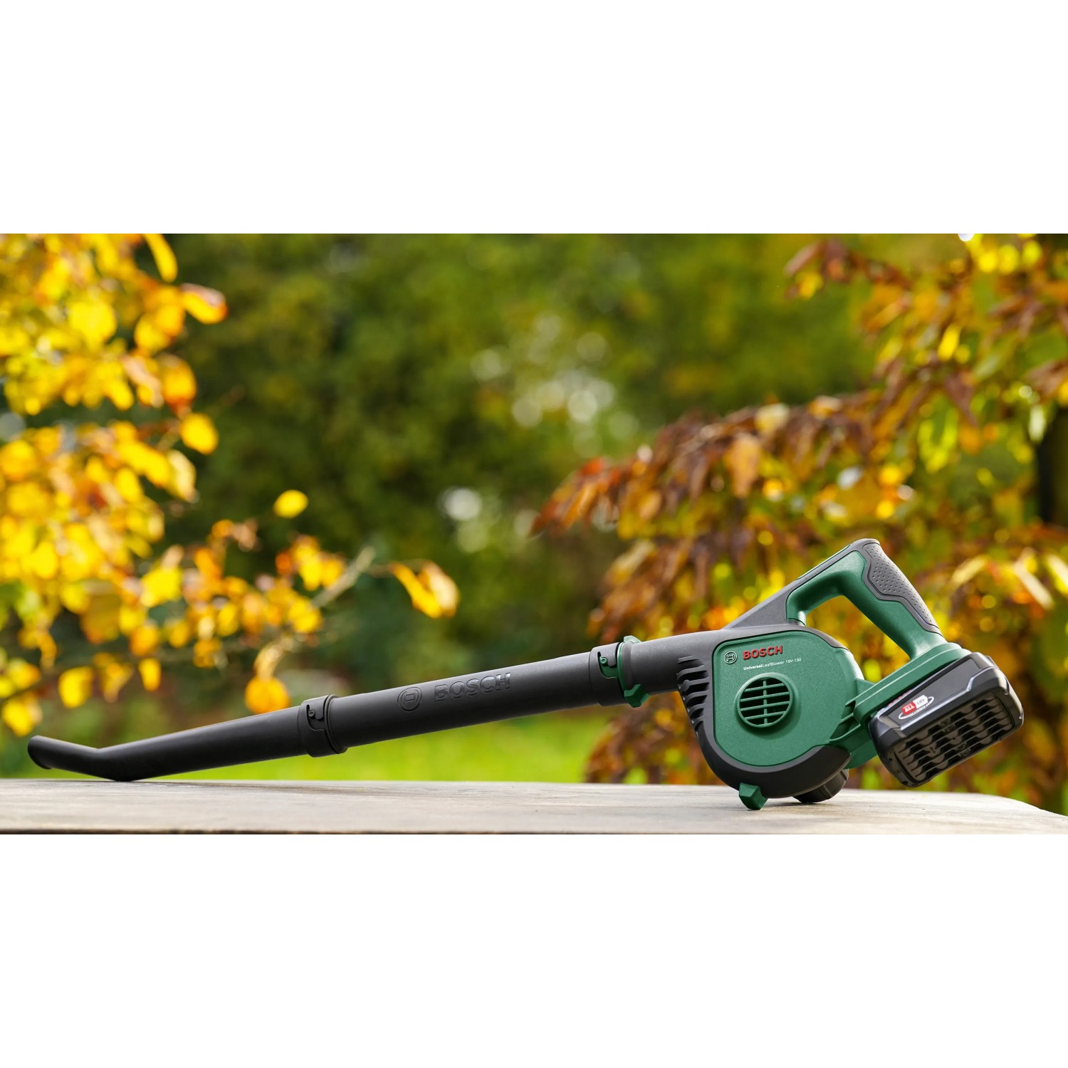 Bosch Akku-Laubbläser UniversalLeafBlower 18V-130 mit Akku und Ladegerät im Garten.