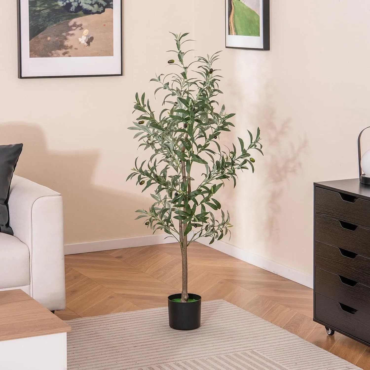 Künstlicher Olivenbaum 130 cm mit grünen Blättern und dunklen Früchten im schwarzen Topf, als Kunstpflanze für Wohnräume.