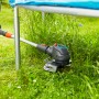 Gardena Akku-Rasentrimmer ComfortCut 23/18 im Einsatz unter einem Trampolin im Garten.