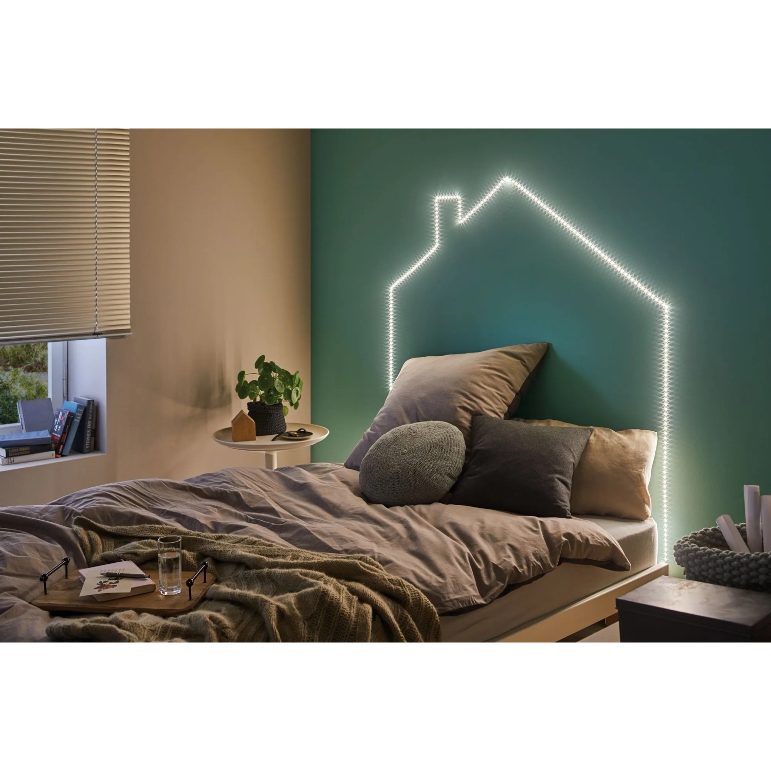Paulmann FlexLED 3D Basis-Set als warmweiße Haus-Leuchtschrift über einem Bett.
