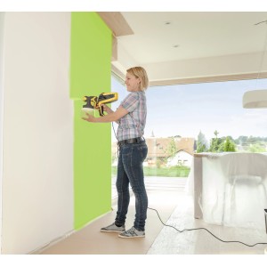 Frau sprüht grüne Farbe mit Wagner Farbsprühsystem W 590 an eine Wand.