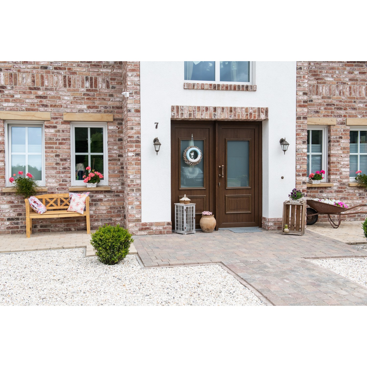 Einfahrt mit Diephaus Pflastersteinen Collo Herbstlaub (21x14x7 cm) vor einem Haus.