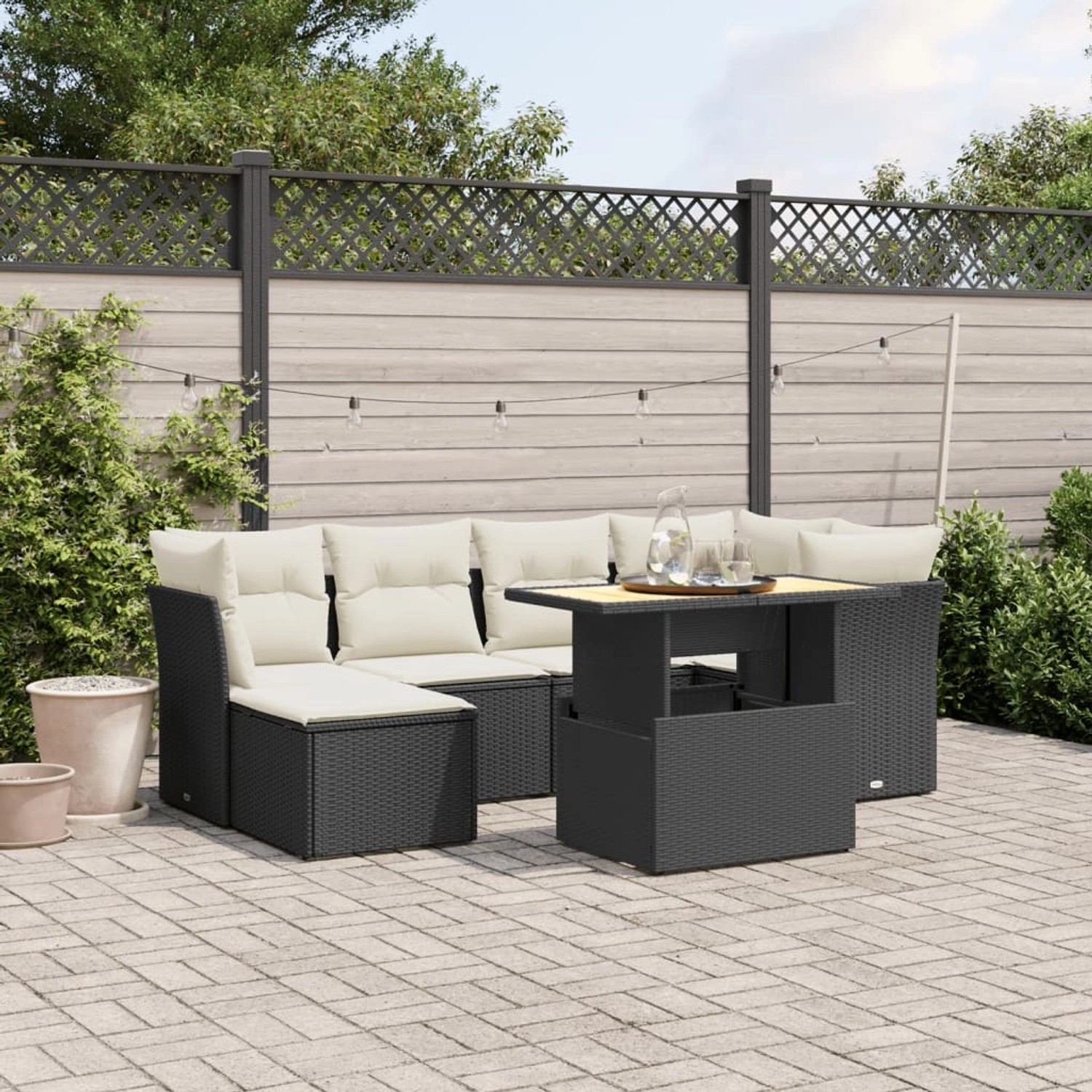 Schwarze 7-tlg. vidaXL Garten-Sofagarnitur aus Poly Rattan mit Tisch und cremeweißen Kissen.