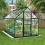Grünes Palram Canopia Gewächshaus 5,7 m² mit Fundamentrahmen im Garten.