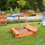 Holz Sandkasten Buddelkiste mit blauem Dach und Sitzbänken im Garten.