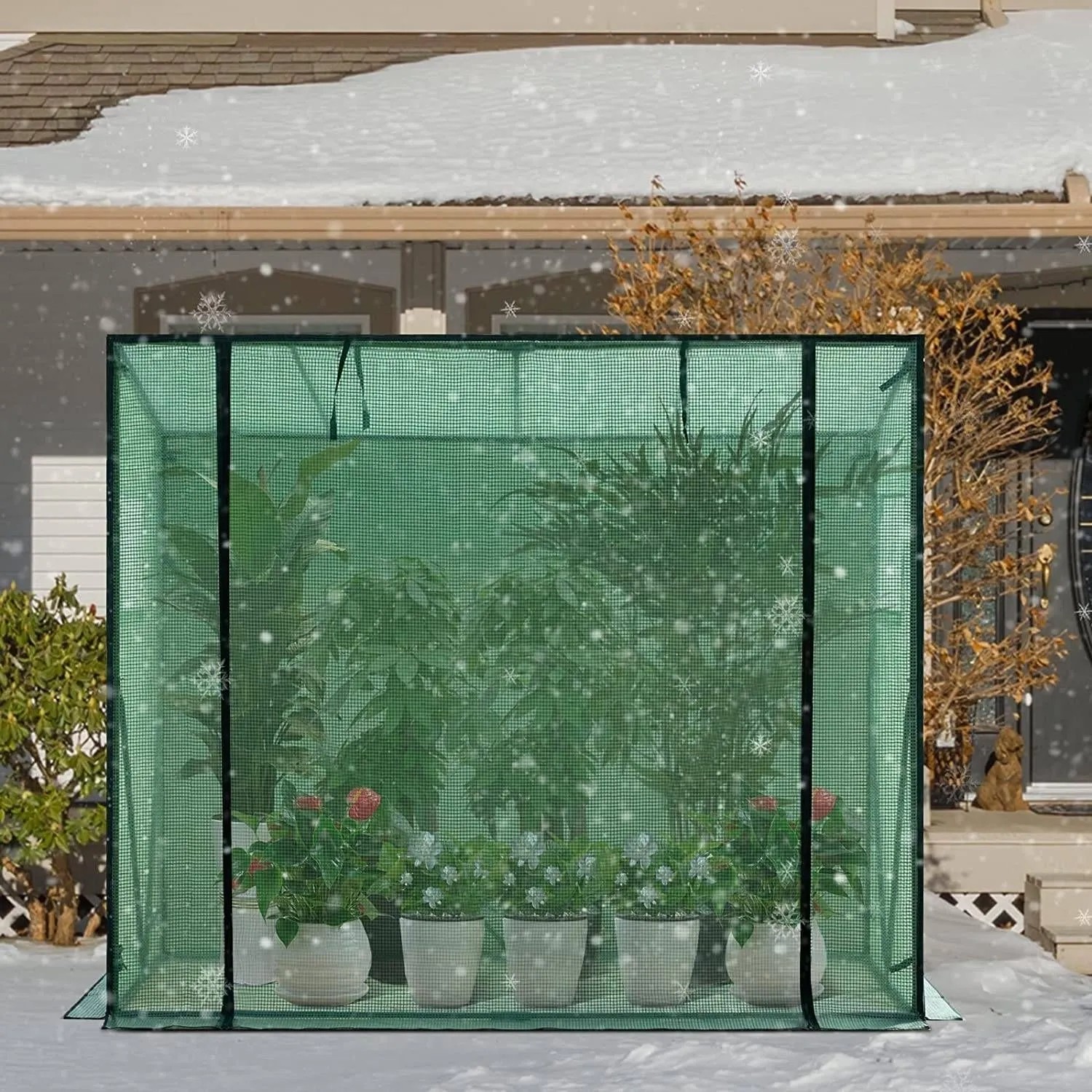 Grünes WOLTU Foliengewächshaus mit halbtransparenter PE-Plane, schützt Pflanzen im verschneiten Garten vor Kälte.