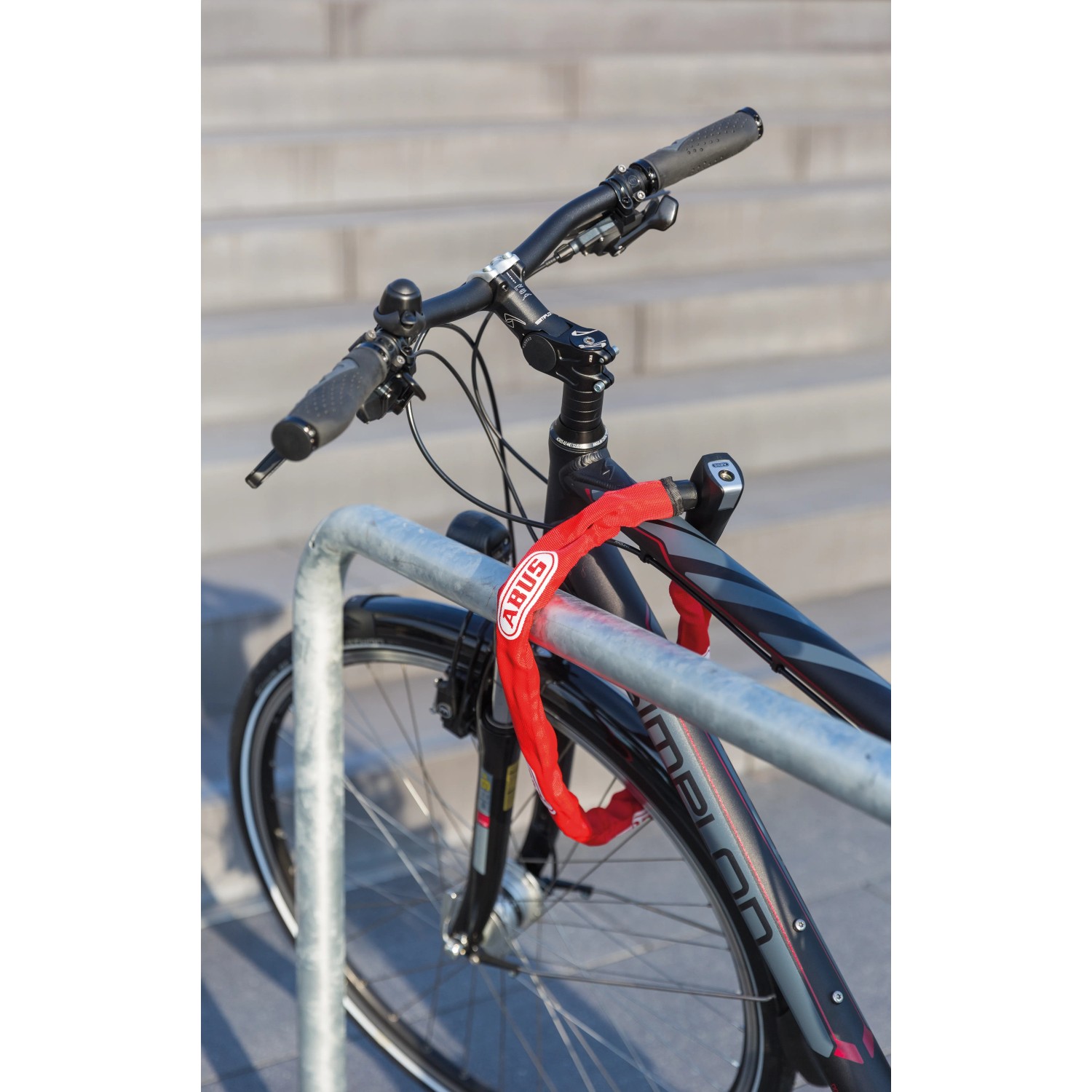 Abus Kettenschloss CH Lock 5406 am Fahrrad befestigt, rote Kette mit Textilschlauch.