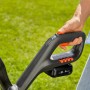 Gardena Akku-Trimmer EasyCut 23/18V: Detailaufnahme von Griff und Akku vor Rasen.