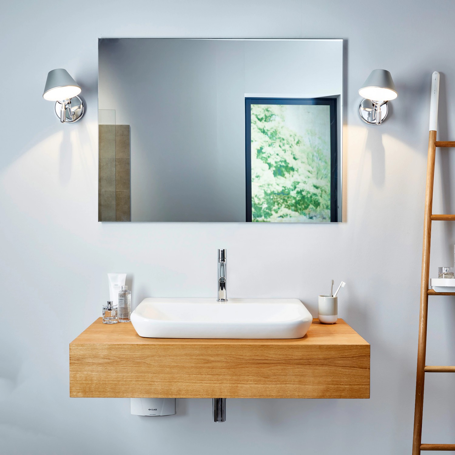 Badezimmer mit Clage Kleindurchlauferhitzer M3 unter Waschbecken mit Holzunterschrank.