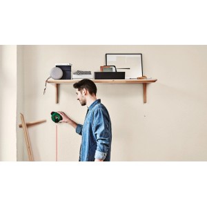 Mann benutzt Bosch Atino Linienlaser mit Maßband zum Ausrichten an einer Wand.