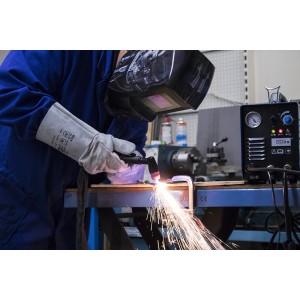 Schweißer mit Güde Schweißhandschuhen beim Schweißen mit Funkenflug.