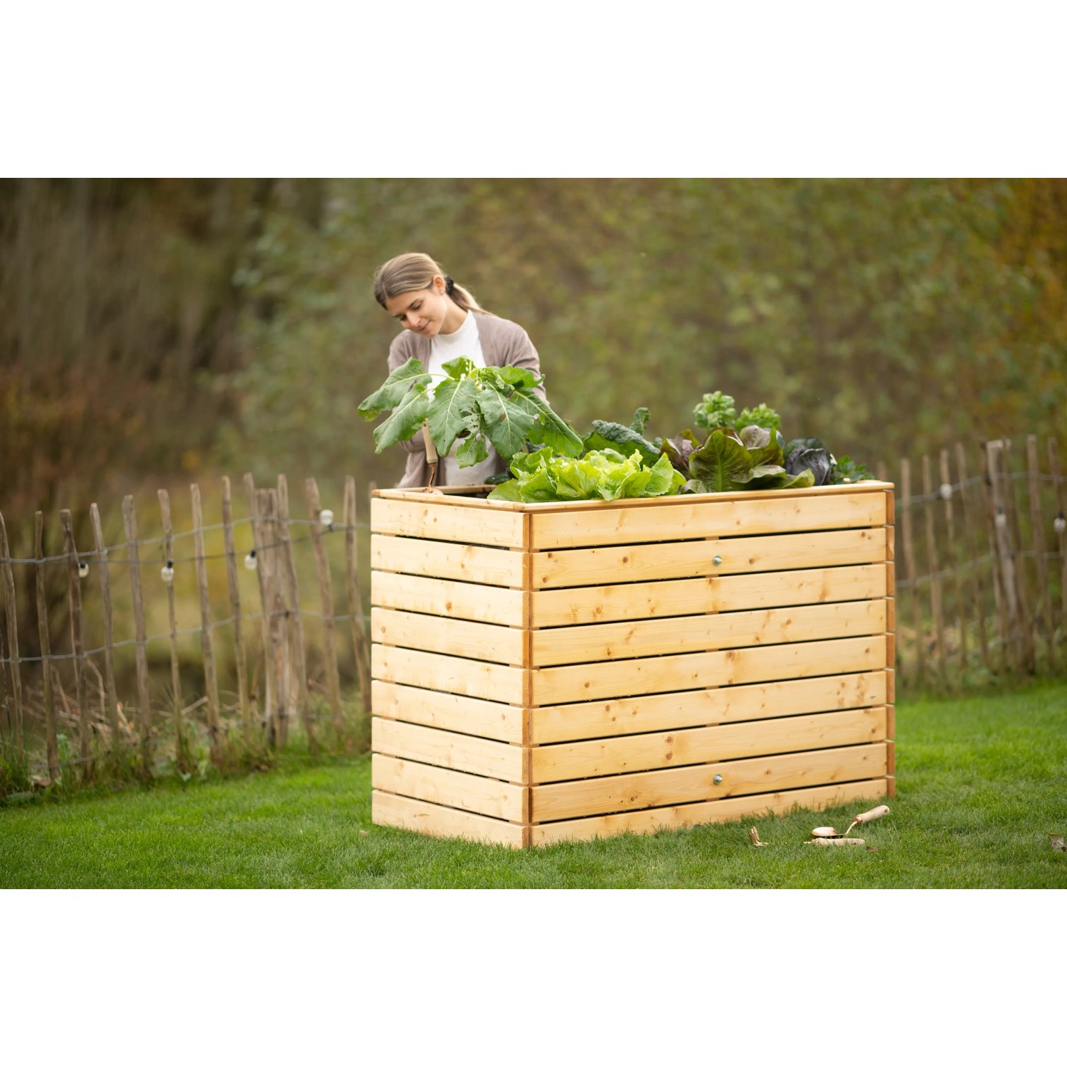 Westmann Hochbeet aus Fichte (Größe L) mit Bepflanzung und Frau im Garten.