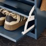 Detailaufnahme: Blaue Schuhbank mit Sportschuhen in der Klappe.