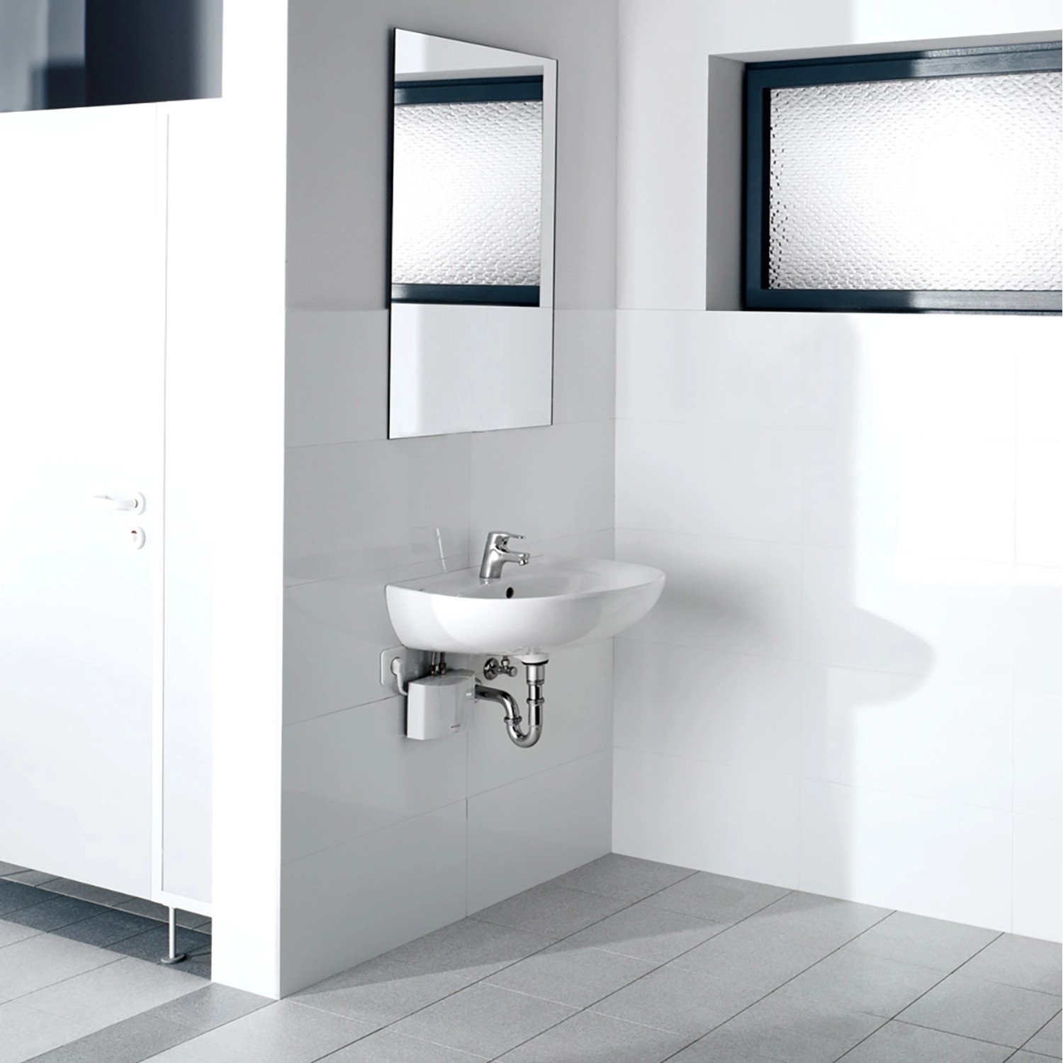 Clage Kleindurchlauferhitzer M3 unter Waschbecken in weißem Bad.