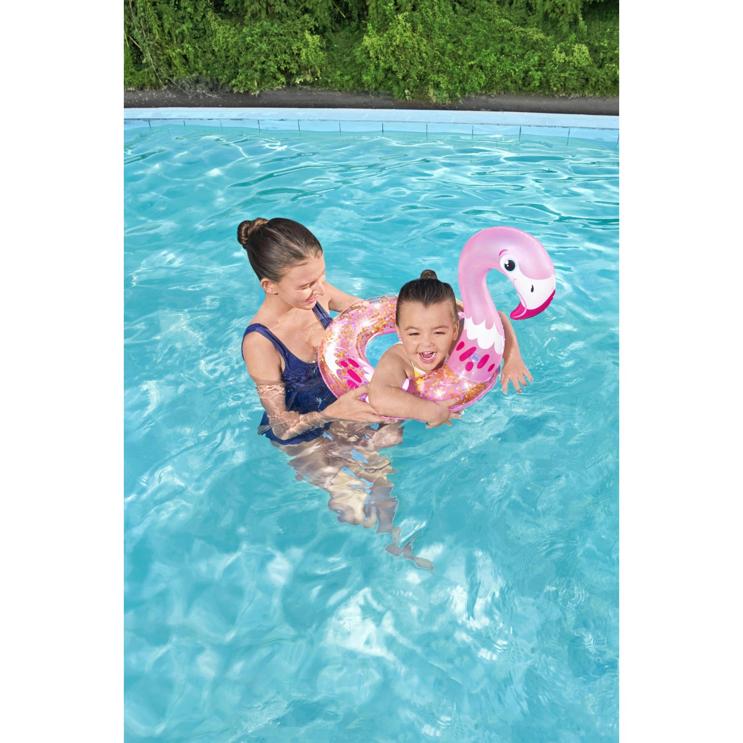 Mädchen mit Bestway Schwimmring (Flamingo) im Pool. Glitzernder Schwimmreifen mit Tierkopf.