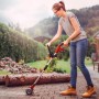 Frau nutzt Einhell Akku-Fugenreiniger GC-CC 18 Li Kit im Garten zur Fugenreinigung.
