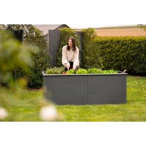 Westmann Hochbeet Primus aus Metall, 2x1m, anthrazit, mit Schneckenschutz. Frau erntet Salat.