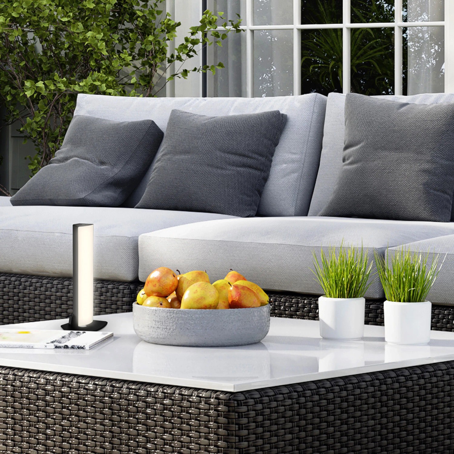 Schwarze Brilo Akku Tischleuchte Zadar (7W) auf Gartentisch mit Deko.