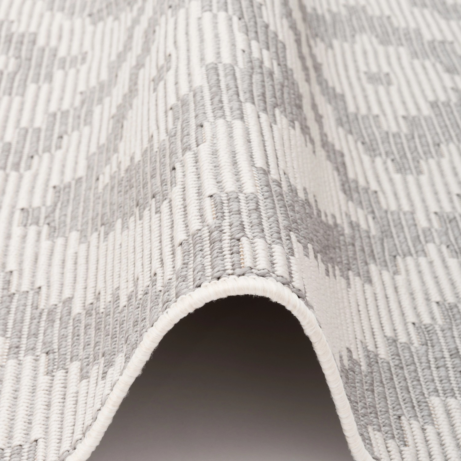 Detailansicht des grauen Pergamon In & Outdoor Teppichs Marbella mit Fliesenmuster, 120x170cm.