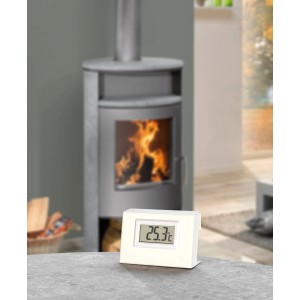 Justus Ferntemperaturanzeige für Aqua-Modelle vor Kaminofen mit Feuer.