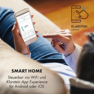 Person steuert Klarstein Wonderwall Smart Infrarotheizung per App auf Smartphone. Smart Home Heizkörper.
