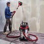 Einhell TE-VC 2025 SACL Nass-Trockensauger im Einsatz mit Schleifgerät an Wand.