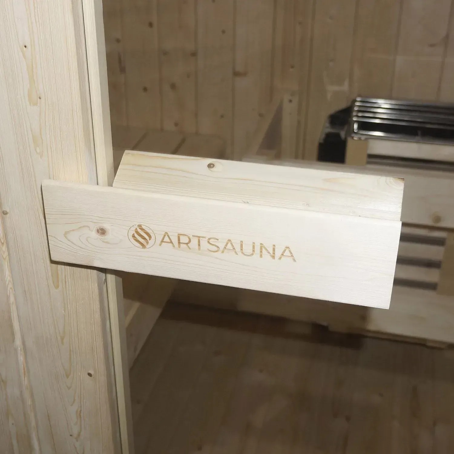 Detailansicht Artsauna Cube Fasssauna Nolvik M: Holzbalken mit Logo im Inneren der Gartensauna.