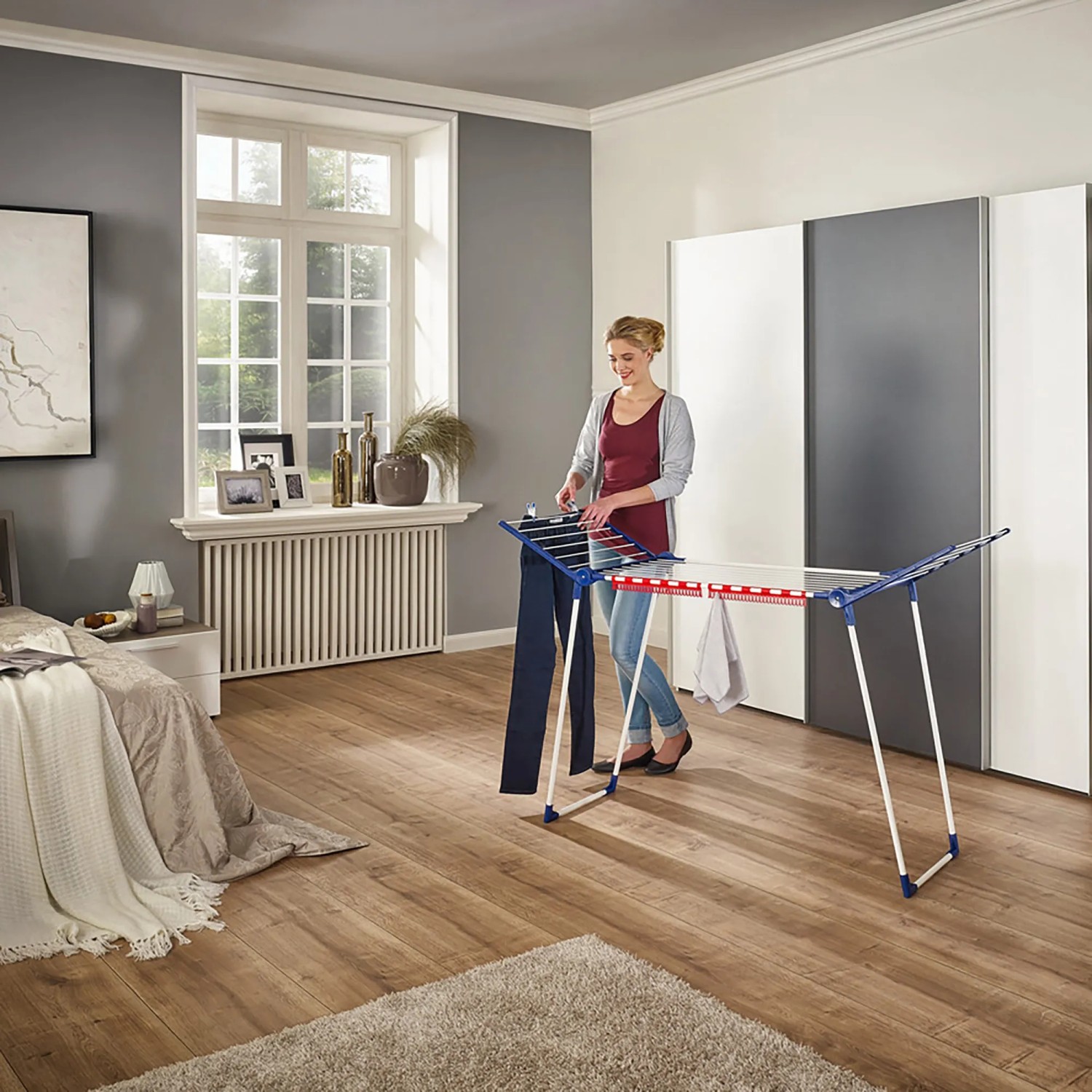 Leifheit Wäscheständer Pegasus 150 Solid Slim mit Frau beim Wäsche aufhängen.