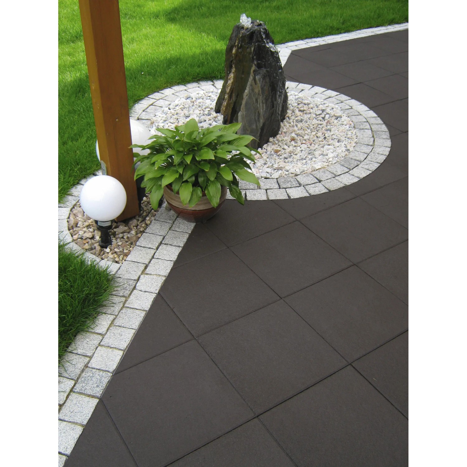 Diephaus Terrassenplatten Finessa in Schwarz-Basalt auf einer Gartenterrasse mit Dekoration.