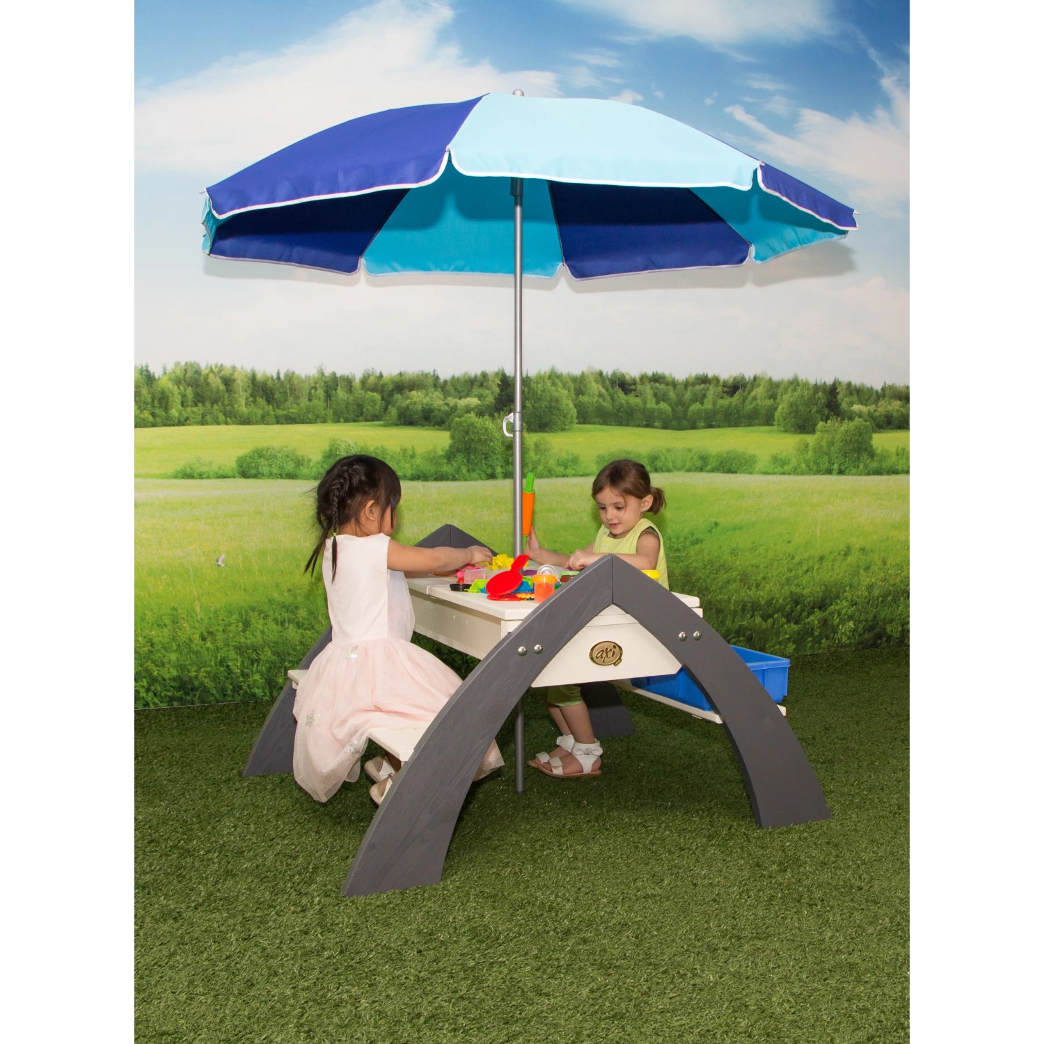 Sand- und Wassertisch Delta mit Sonnenschirm: Kinder spielen am grauen Picknicktisch mit Spielzeug.